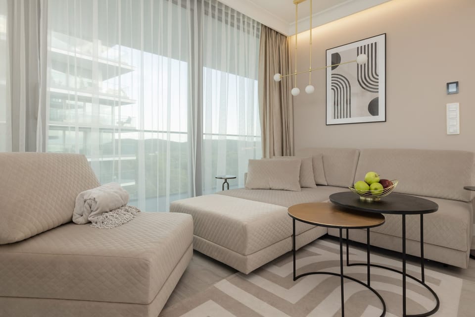 Cozy living area with a neutral-toned sofa, modern coffee table, and large windows for plenty of daylight.

