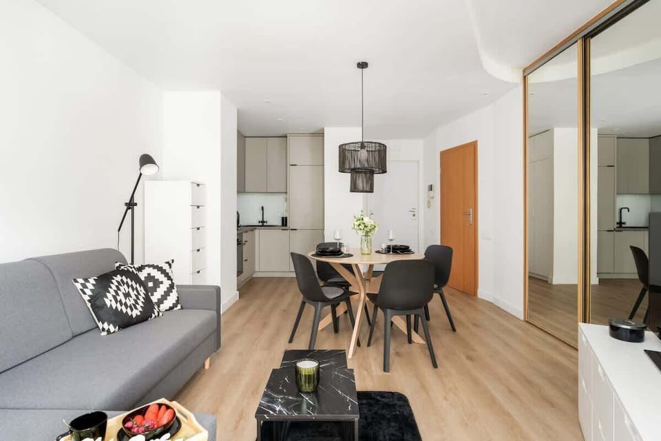 Open living and dining space with warm wood flooring and chic interior accents.

