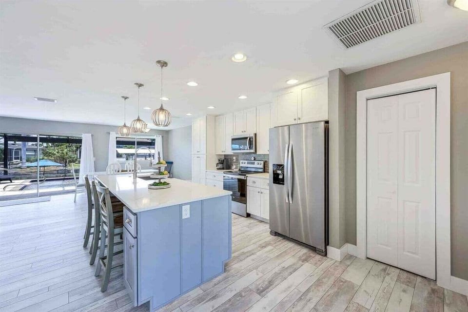Large Kitchen Island with Stainless Appliances and Fridge with Ice Maker