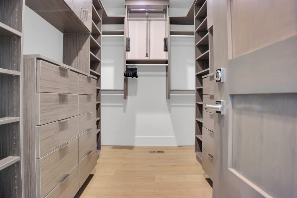 Vacation rental main suite walk in closet with custom cabinetry.