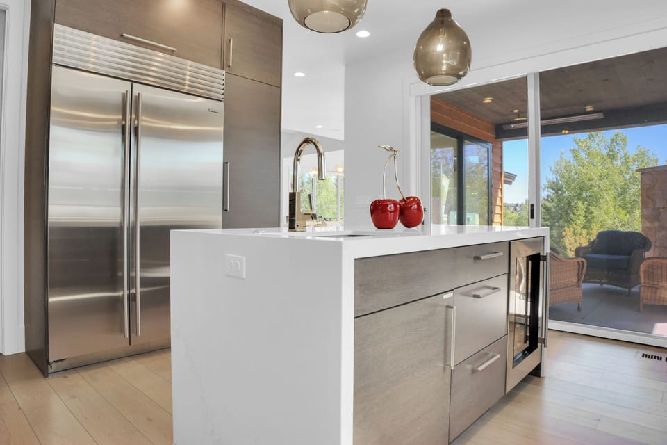 Vacation rental kitchen with waterfall island and sliding glass doors leading to the covered patio.