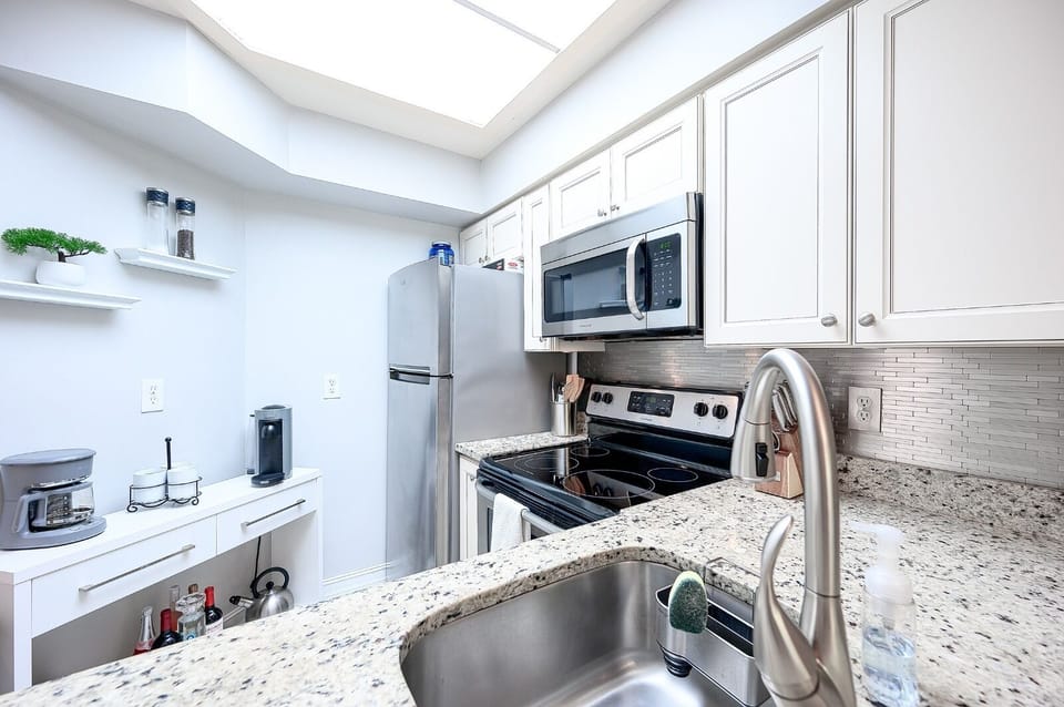 kitchen with granite counters, stainless appliances, Nespresso Coffee Machine