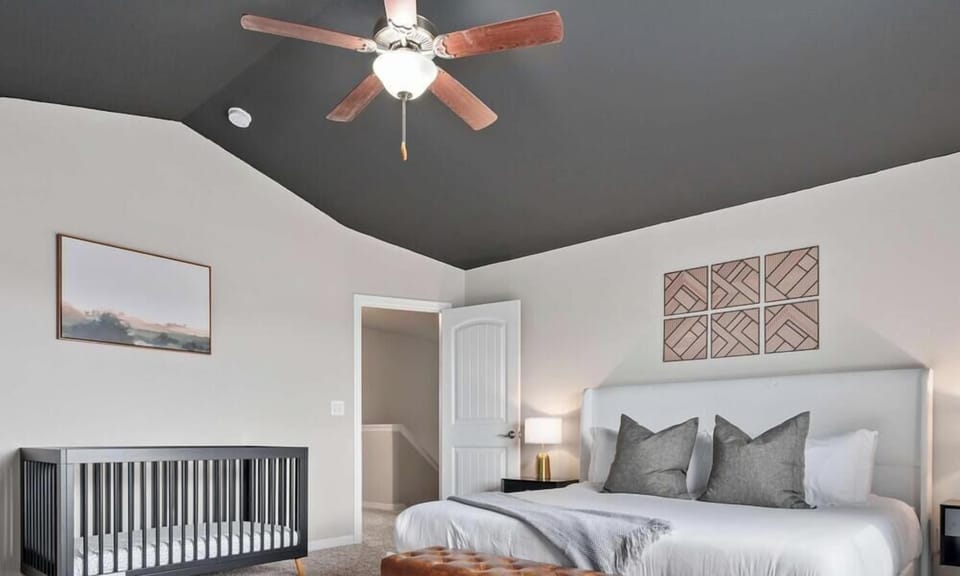Master bedroom with king bed, crib bed, 50" TV and attached bathroom