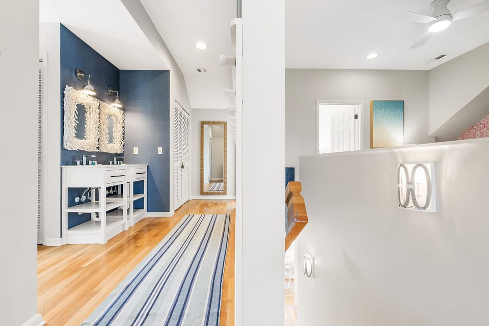 Stairs to open upper level of home - double vanity one side; living area other