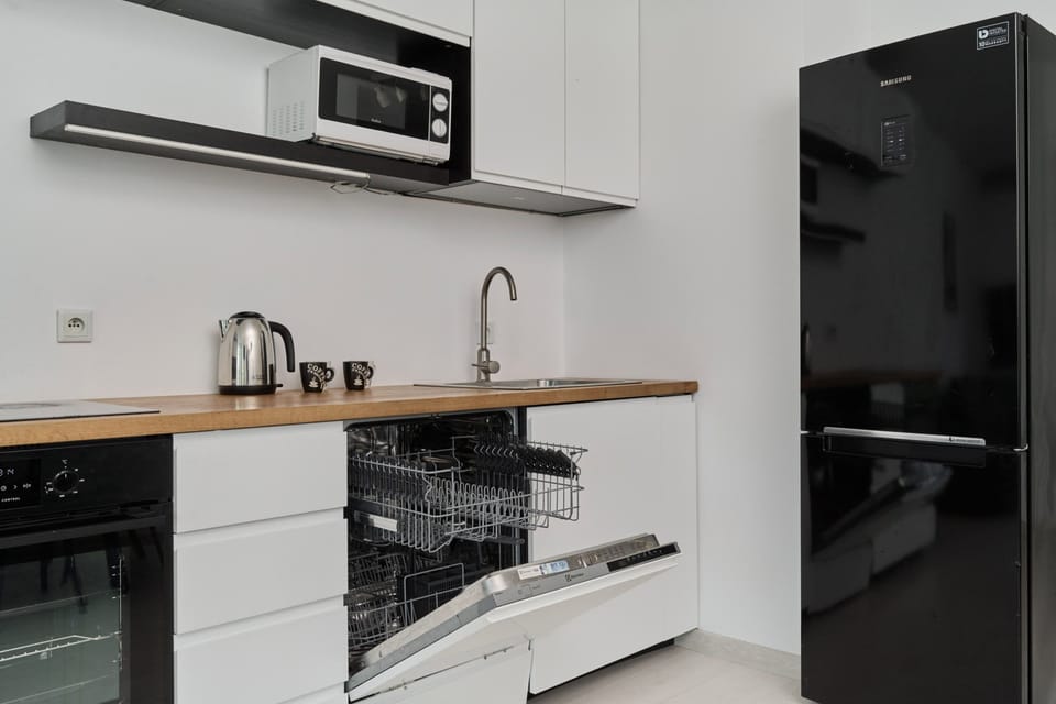 Fully equipped kitchen with a compact layout, modern appliances, and a clean design.


