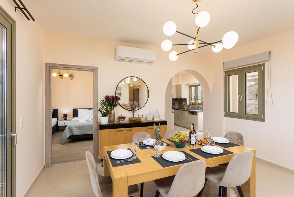 Open-plan living room with sofa, dining area, kitchen, A/C, WiFi internet, and satellite TV