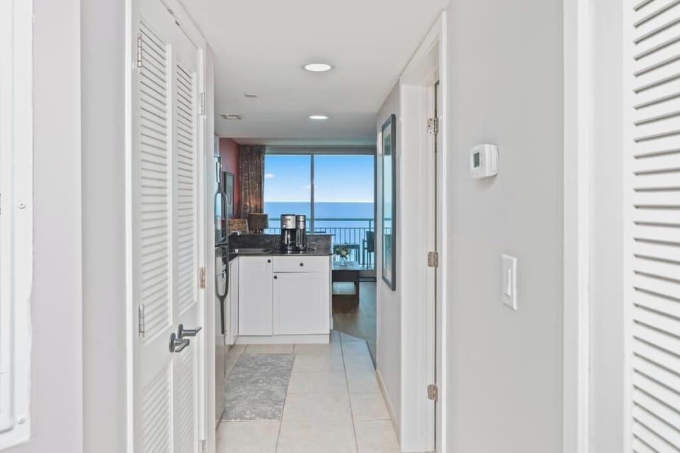 The unit features a tidy, well-lit hallway that connects the living spaces