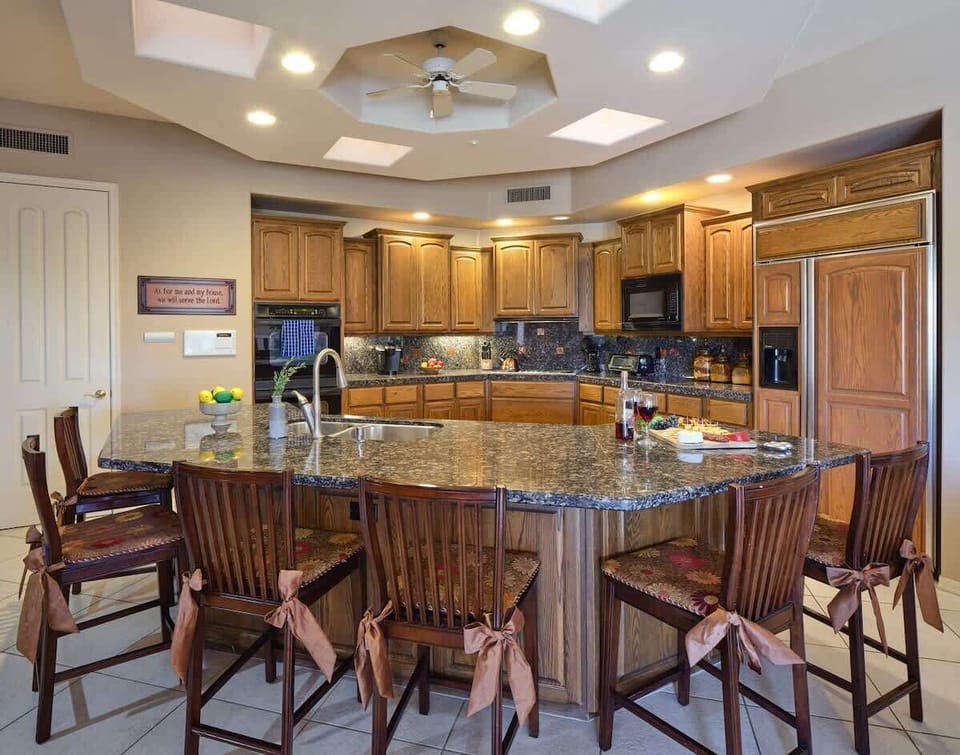 Kitchen fully equipped with high-end appliances, stocked with all culinary essentials. Featuring an oversized island with bar seating