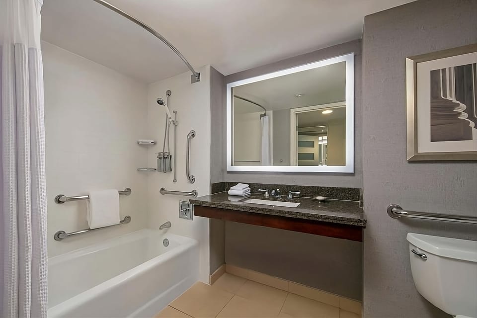 Refresh in a spotless bath with bright vanity lighting.