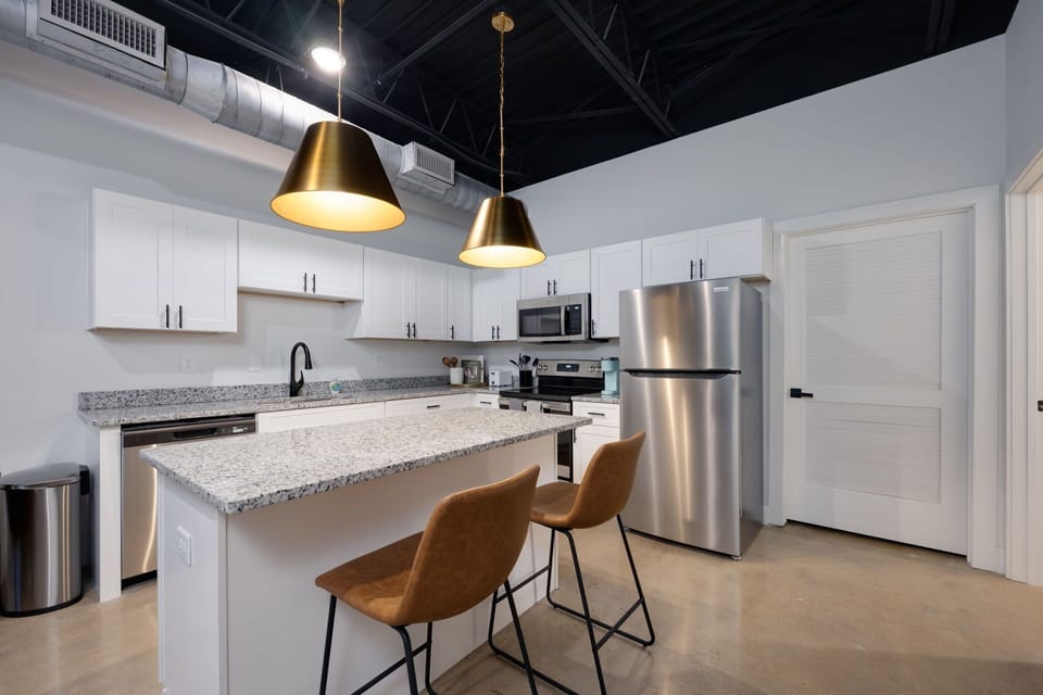 Discover a sleek and modern kitchen adorned with clean lines, white cabinets, and stainless steel appliances, creating an elegant and functional culinary space.