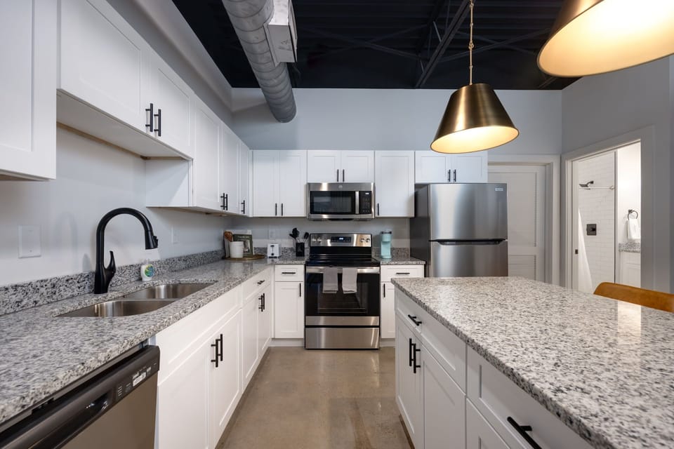 Experience the epitome of elegance in your own home with this pristine kitchen adorned with pristine white cabinetry and premium stainless steel appliances.