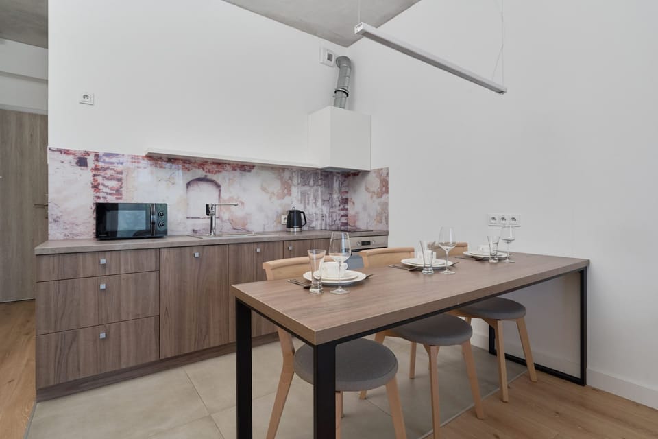 Open-plan kitchen and dining space with wooden cabinets and a compact dining table.

