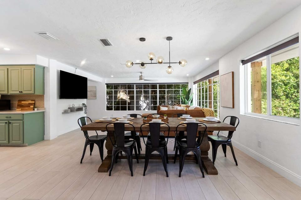 Stylish open-concept design with dining area, green kitchen, and living space