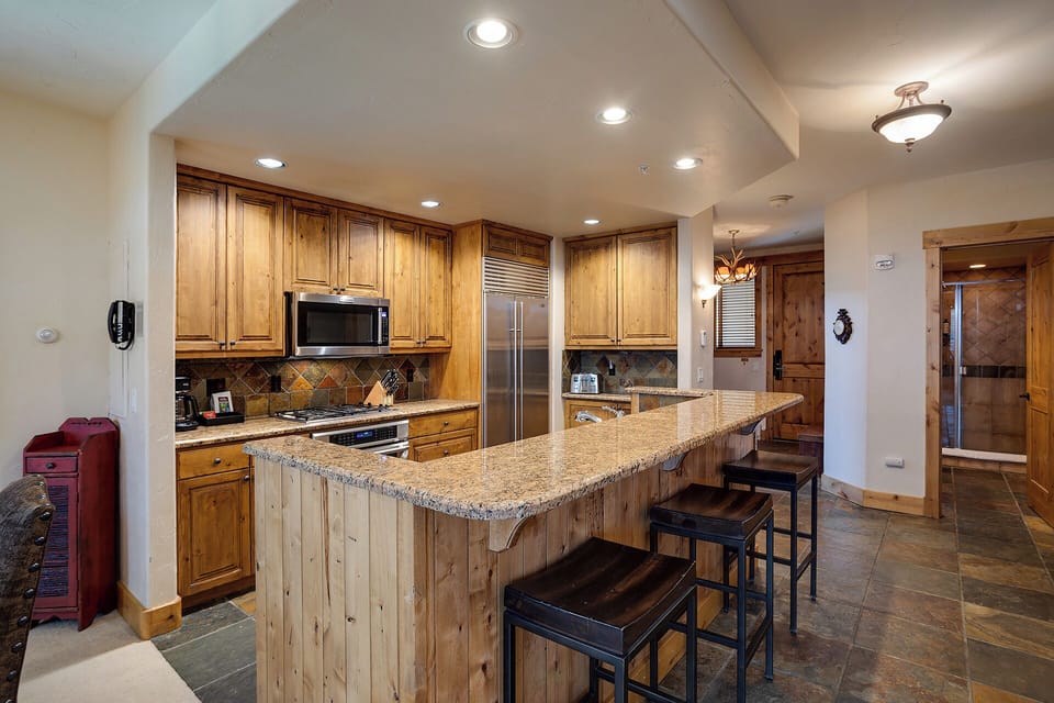 Your fully-equipped kitchen features warm wood cabinets, granite counters, and a spacious island where you'll create memorable meals together.