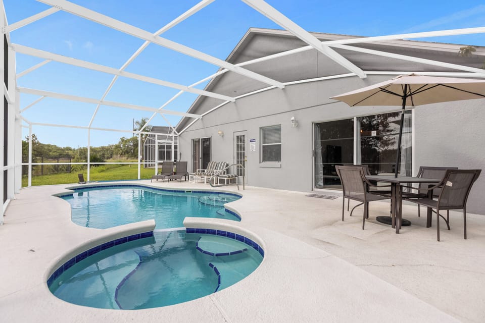 Private screened pool & spa with loungers and shaded outdoor dining