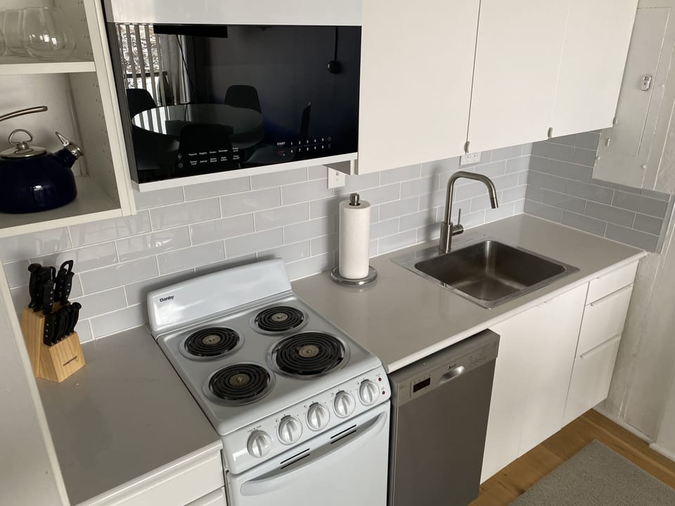 Kitchen complete with pots, pans, dishes, silverware, and cooking utensils.