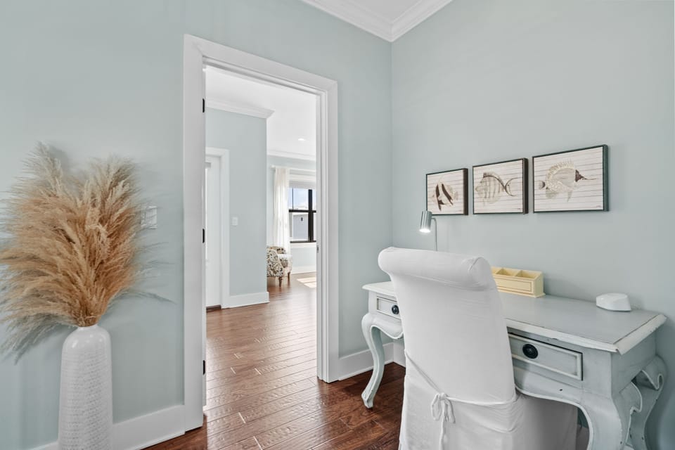 Charming hallway workstation with a vintage-style desk and coastal decor—perfect for catching up on emails or journaling between beach outings.