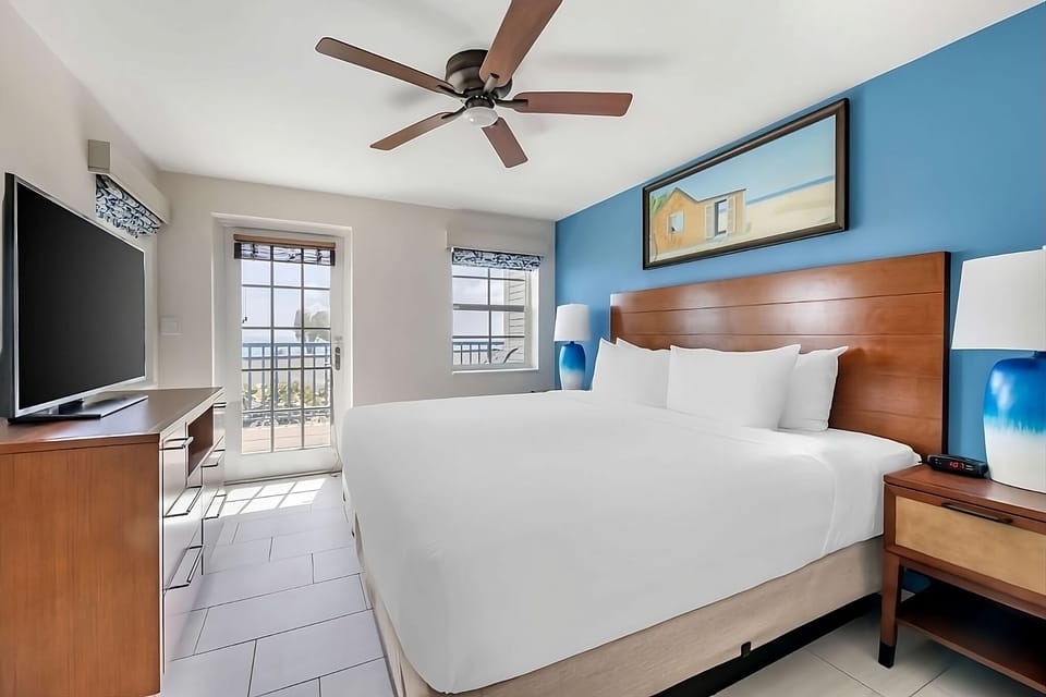 Unwind in crisp linens with balcony breeze and sunlight.