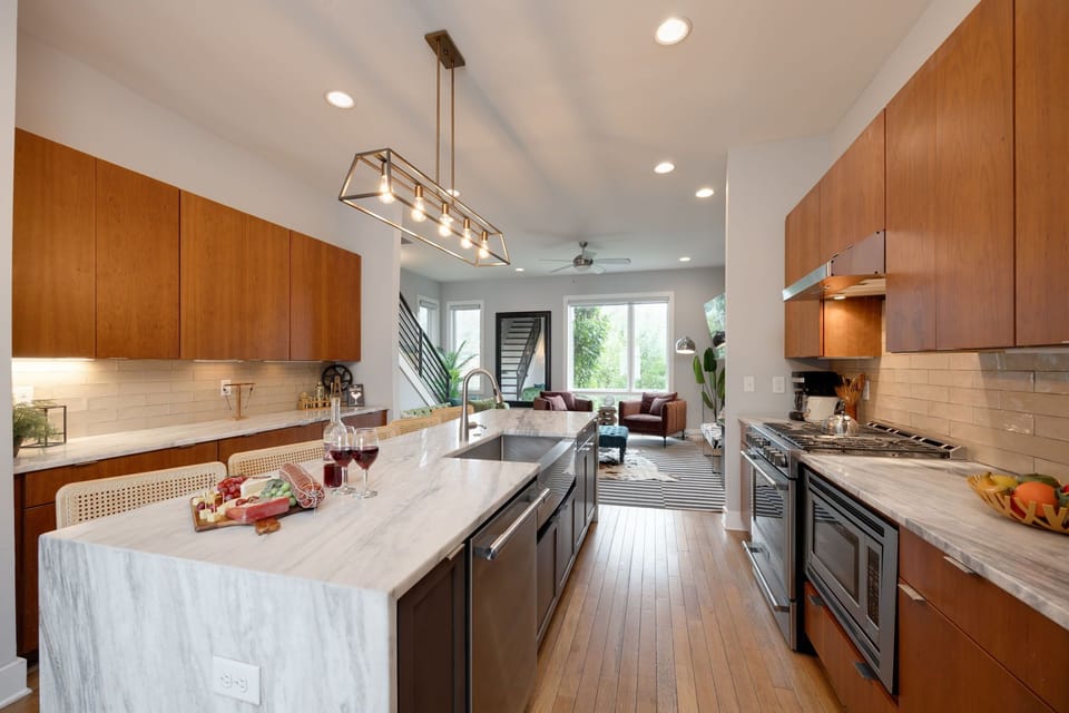 2nd Floor: Fully equipped kitchen with stainless steel appliances and stocked with all culinary essentials. Features an island with bar seating and ample counter space.