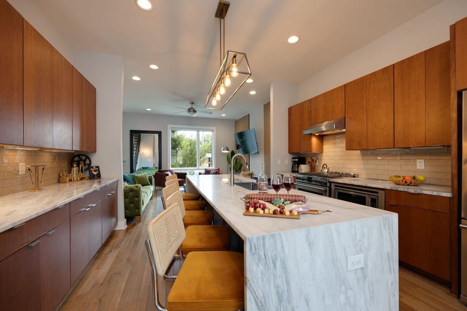 2nd Floor: Fully equipped kitchen with stainless steel appliances and stocked with all culinary essentials. Features an island with bar seating and ample counter space.