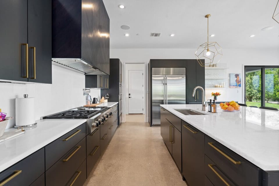 Bright, fully equipped kitchen featuring contemporary appliances and a roomy island counter.