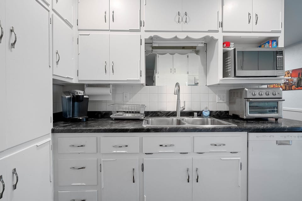 The crisp white and versatile kitchen features in unit laundry. microwave, fridge, freezer, Keurig, toaster oven,  and everything needed to make a home cooked meal. 