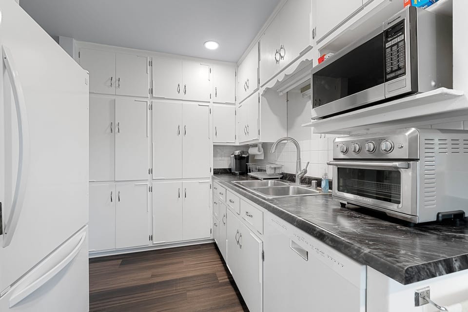 The crisp white and versatile kitchen features in unit laundry. microwave, fridge, freezer, Keurig, toaster oven,  and everything needed to make a home cooked meal. 