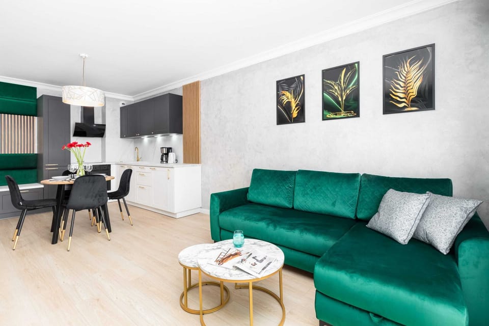 Stylish living room with a spacious green sofa and elegant decor in a light and airy layout.

