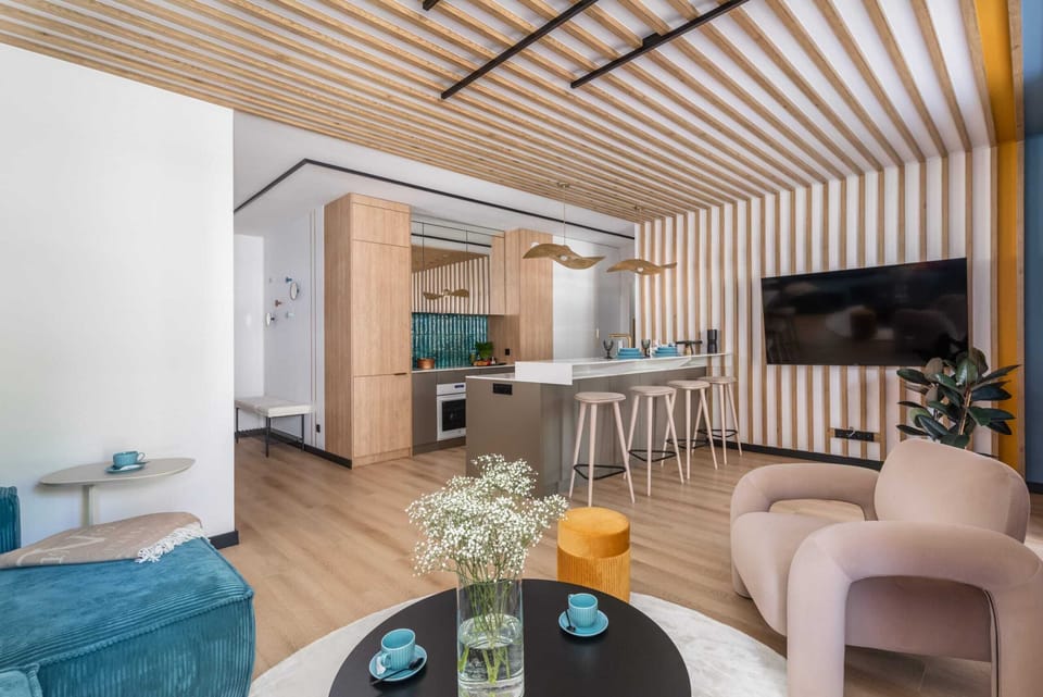 Open kitchen and living room with a blend of natural wood accents and contemporary design.

