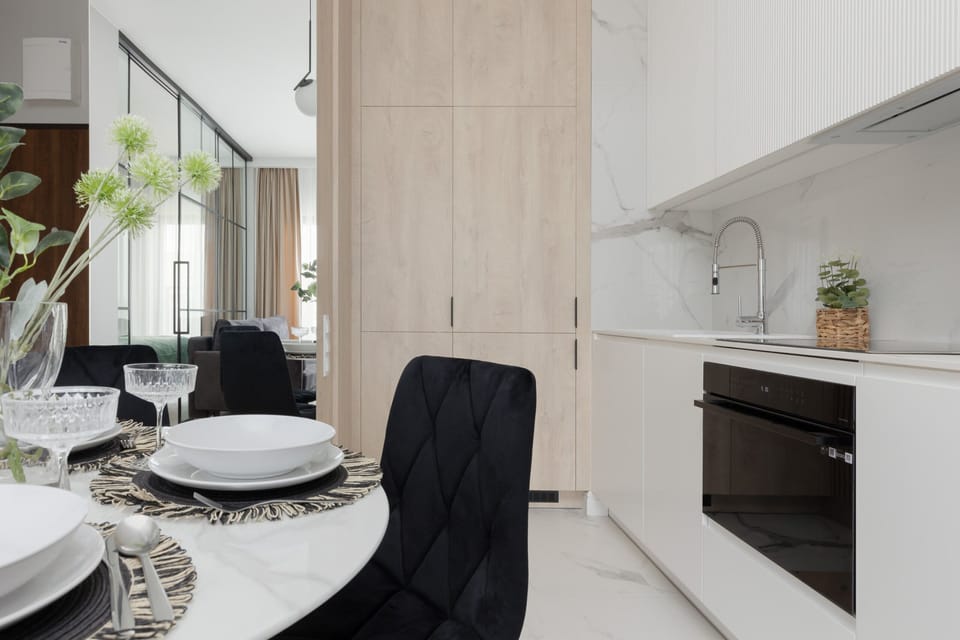 Table setting in a modern dining area with black chairs and stylish decor.

