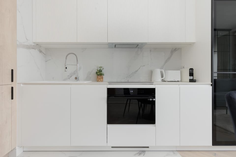 Contemporary kitchen with integrated appliances, white cabinets, and a sleek finish.

