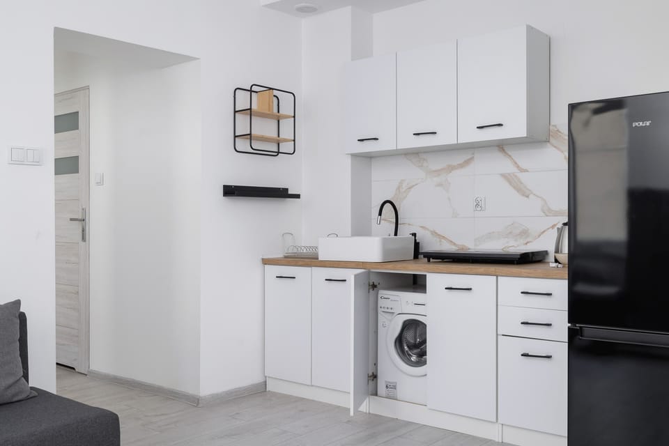 Fully equipped kitchen with integrated appliances and a clean white finish.

