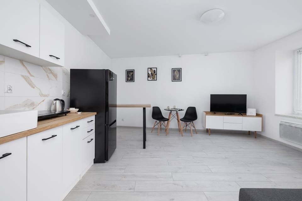 Open-concept kitchen and living area with a simple, modern layout and light tones.

