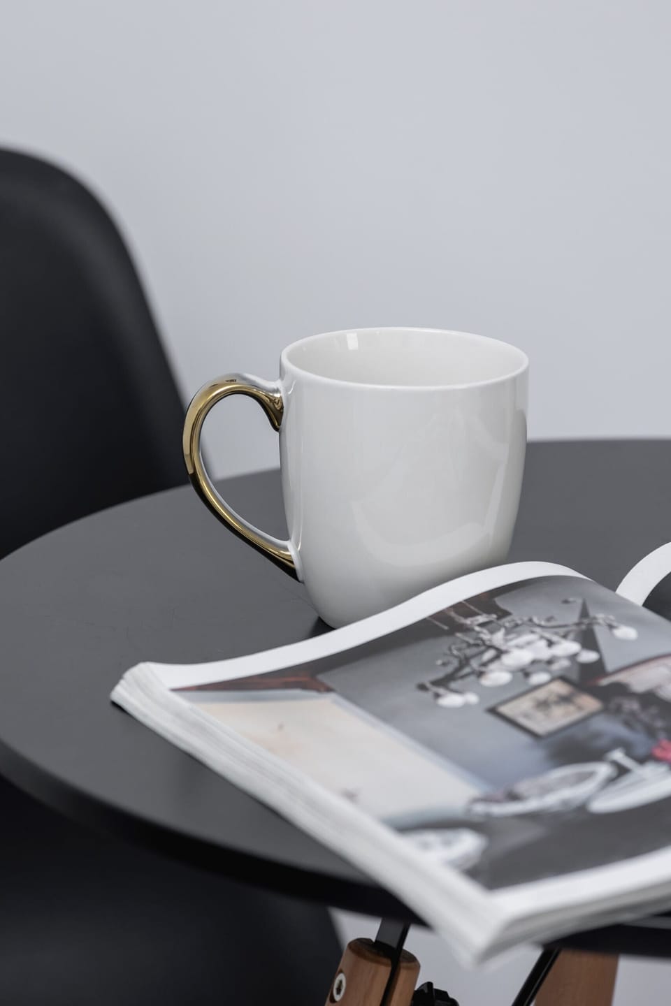 Close-up of a coffee table with a cup, magazine, and stylish decor.

