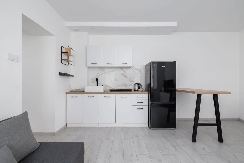 Compact and stylish kitchen with a washing machine, perfect for extended stays.

