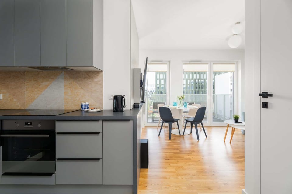 Sleek kitchen with dark cabinets, wooden countertops, and modern fixtures.

