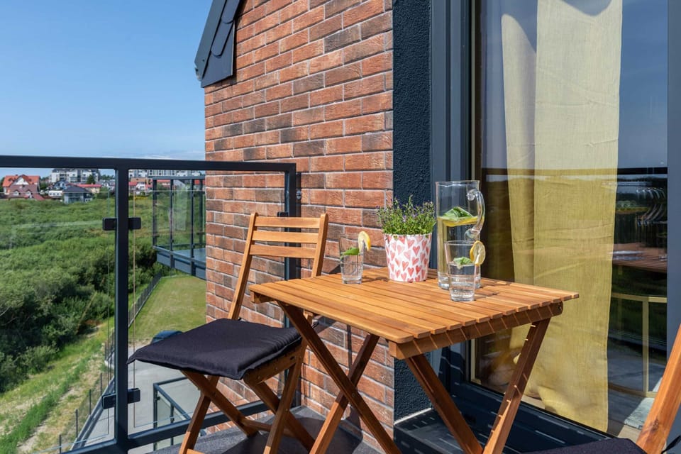Balcony with a wooden table and chairs, offering picturesque views and a cozy outdoor retreat.


