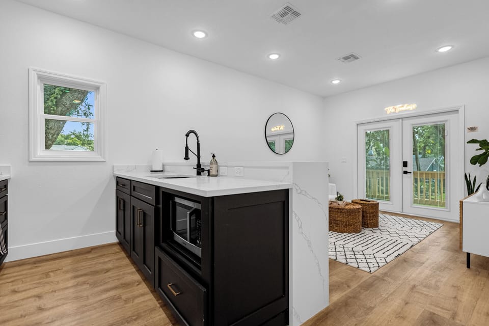 A full kitchen with all high end touches and french doors leading to the balcony