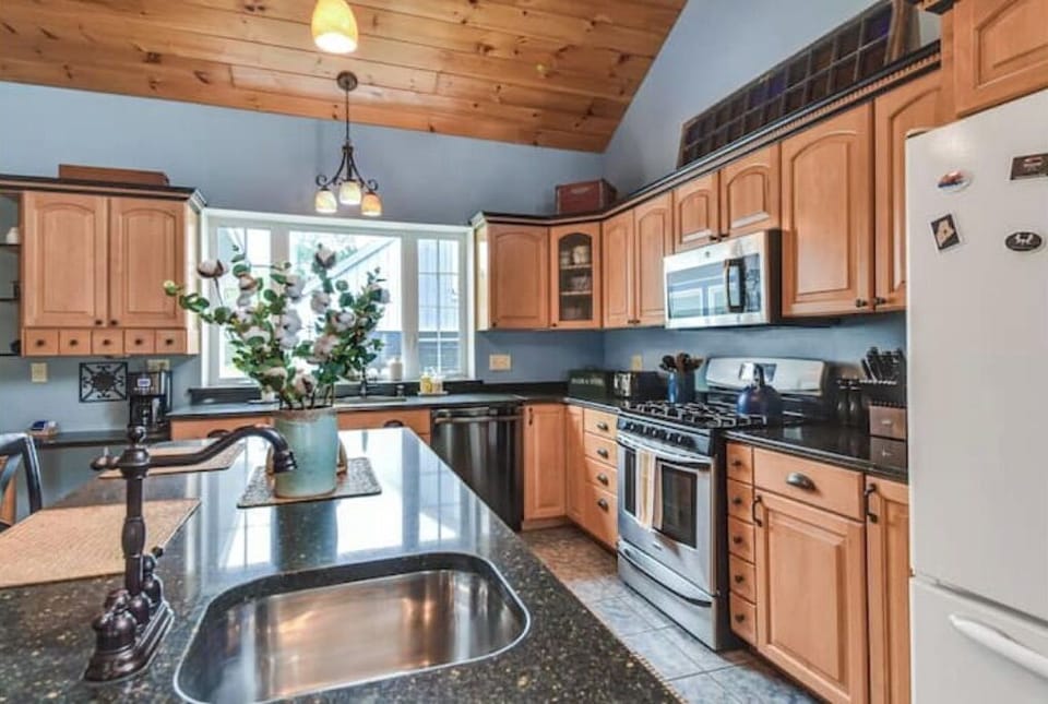 Spacious kitchen has lots of storage and and an island with 3 barstools.