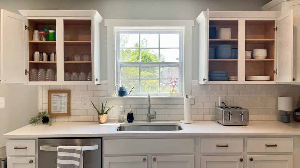 Bright kitchen with double toaster, plates, bowls, and cups. 