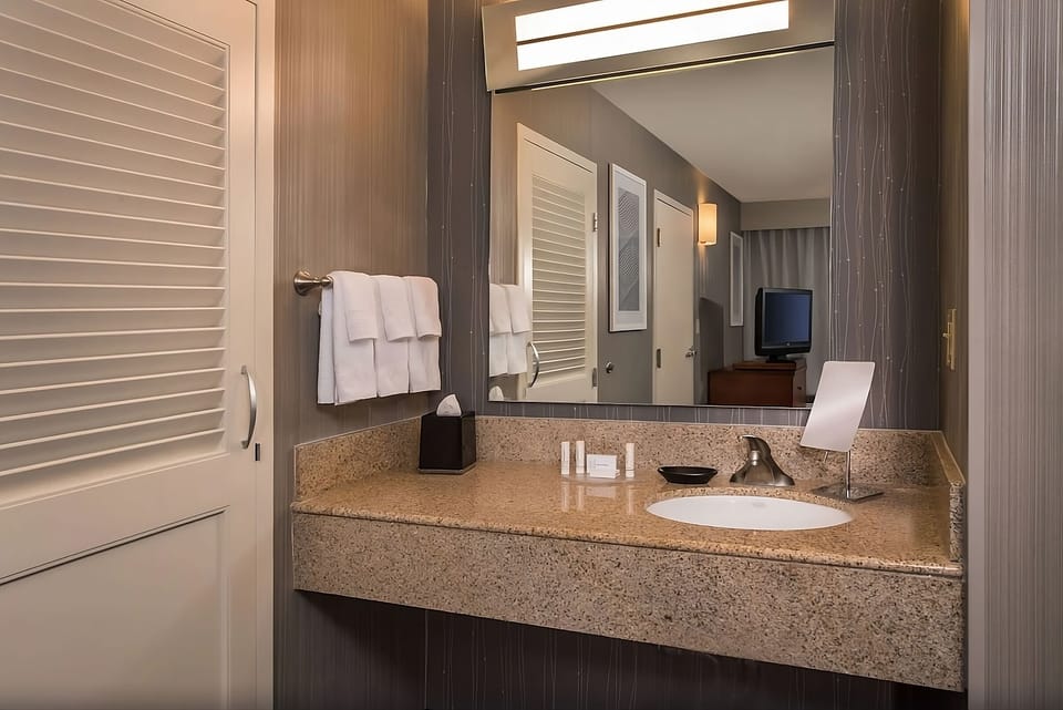Refresh at the granite vanity with bright mirror lighting.