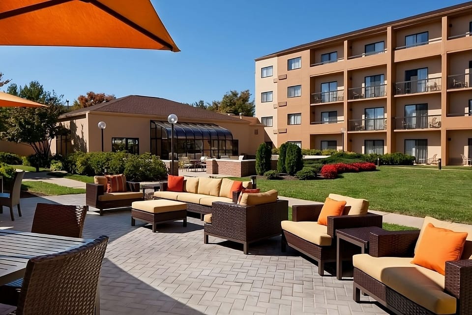 Linger outdoors on cushioned seating in sunny courtyard vibes.