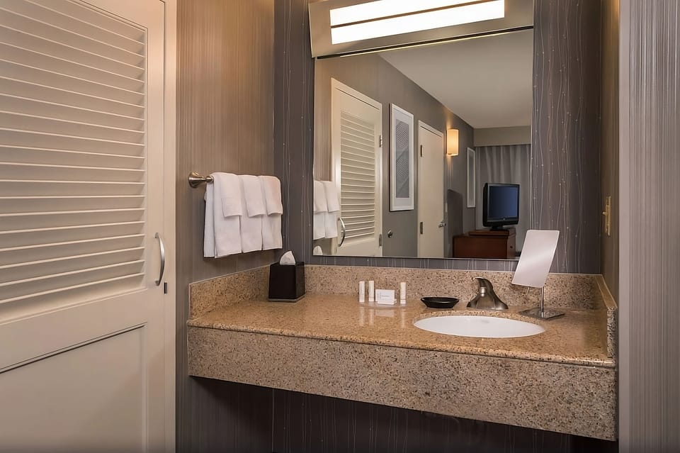 Refresh at the granite vanity with bright mirror lighting.