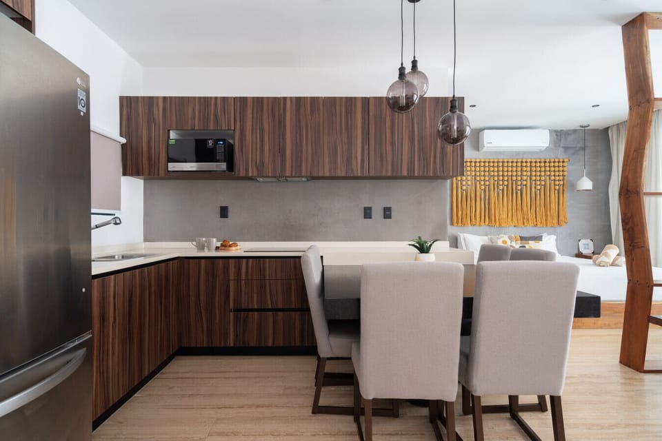 Fully equipped kitchen next to dining table with 6 chairs.