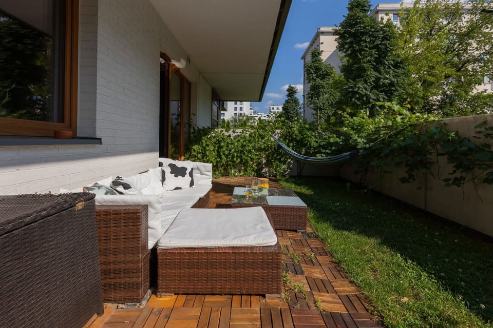 Outdoor patio with comfortable seating and lush greenery, perfect for relaxation.


