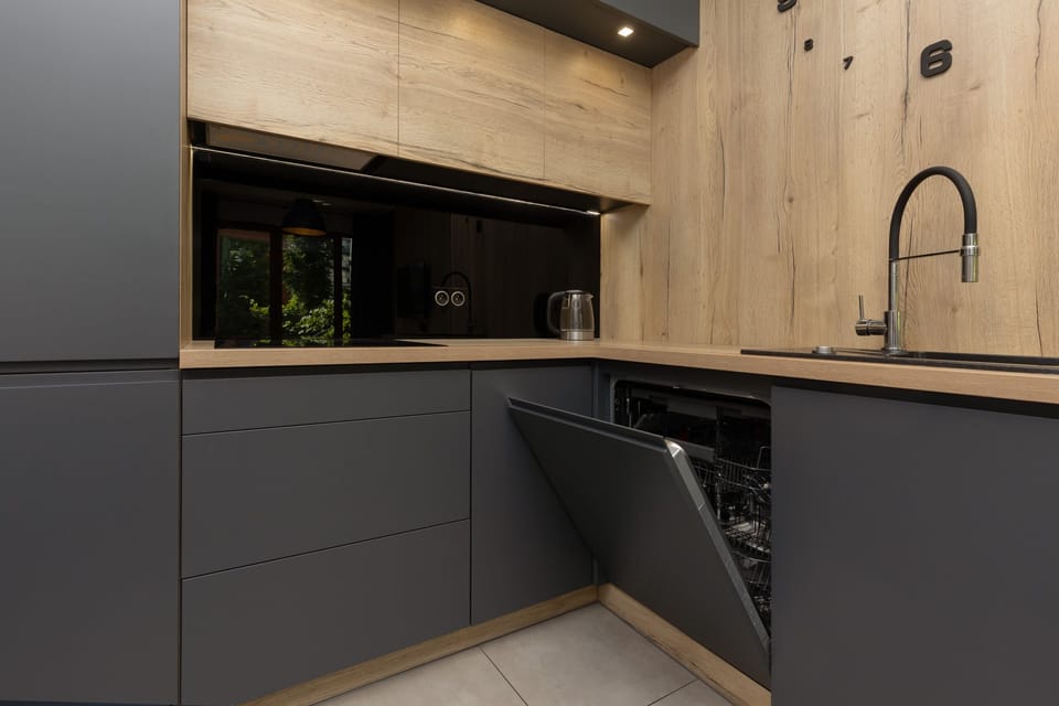 Contemporary kitchen with sleek grey cabinetry, black fixtures, and a clean design.


