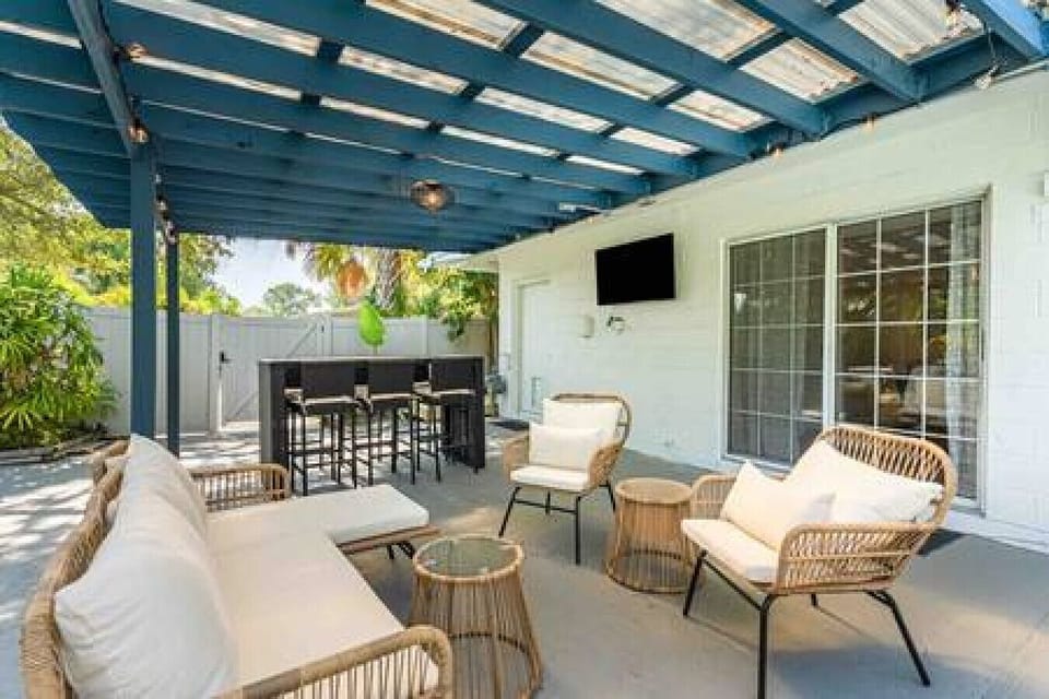 Comfy Wicker Outdoor Furniture Alongside Outdoor Dining Table w/ Seating for Six Underneath Cute Hanging String Lights