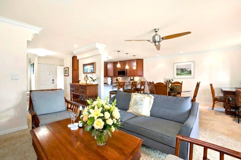 A bright and inviting living space with comfortable seating and large windows that frame gorgeous tropical views.  