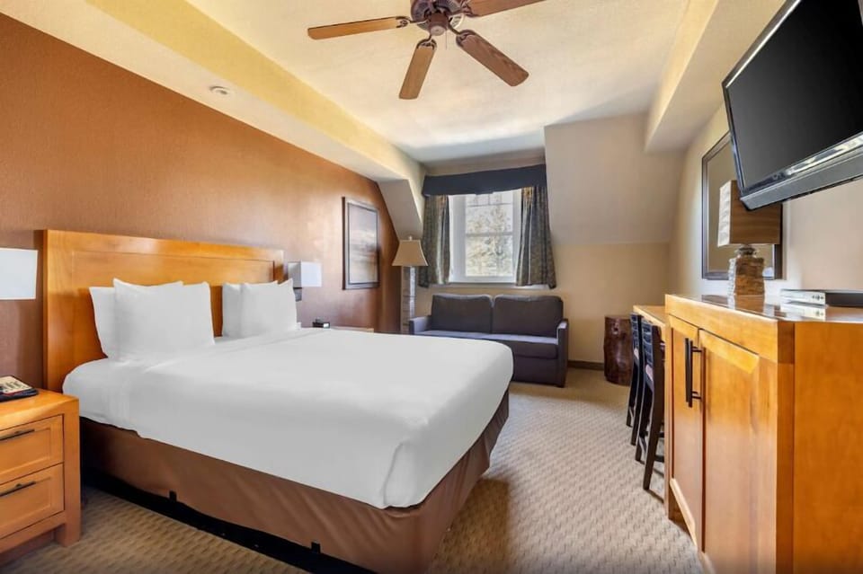 Unwind on a plush king bed with cozy lounge seating.