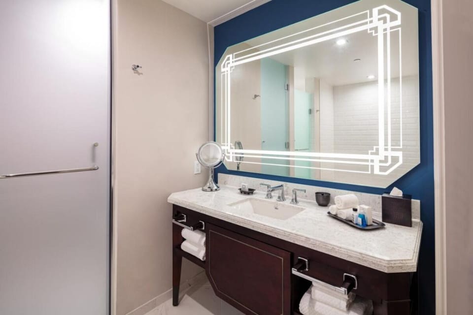 Refresh at the sleek vanity with glowing designer mirror.